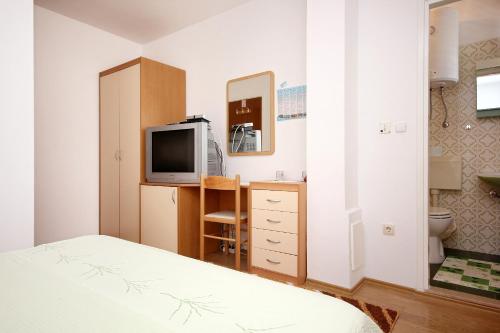 a bedroom with a bed and a tv and a bathroom at Apartment Orebic 4525c in Orebić