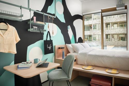 a bedroom with a bed and a table and a desk at lyf Collingwood Melbourne in Melbourne