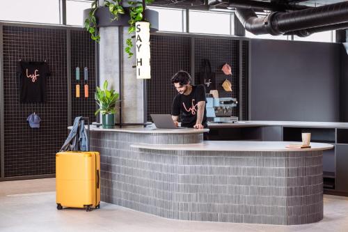 a man standing at a counter with a laptop at lyf Collingwood Melbourne in Melbourne