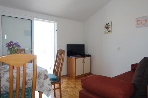 salon z czerwoną kanapą i telewizorem w obiekcie Apartments and rooms with parking space Nin, Zadar - 5805 w Nin