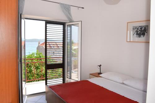 a bedroom with a bed and a view of the ocean at Apartments by the sea Orebic, Peljesac - 4563 in Orebić