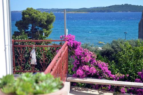 a balcony with purple flowers and a view of the ocean at Studio Orebic 4563d in Orebić
