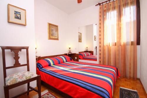a bedroom with two twin beds and a window at Seaside house with a swimming pool Seget Vranjica, Trogir - 4329 in Trogir