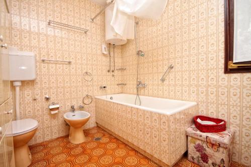 a bathroom with a tub and a toilet and a sink at Seaside house with a swimming pool Seget Vranjica, Trogir - 4329 in Trogir