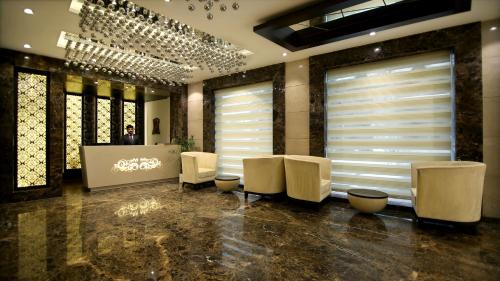a salon with white chairs and a table and windows at Hotel The Prime Balaji Deluxe, City Centre, With Free Airport Pickup in New Delhi