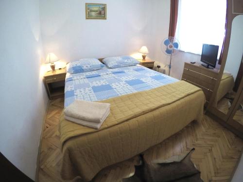 a small bedroom with a bed and two night stands at Apartments by the sea Biograd na Moru, Biograd - 4316 in Biograd na Moru