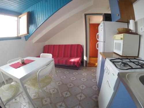 una pequeña cocina con mesa y sofá en Apartments by the sea Biograd na Moru, Biograd - 4316, en Biograd na Moru