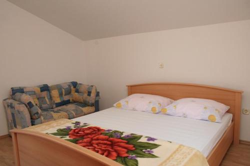 a bedroom with a bed and a couch and a bed and pillows at Apartments by the sea Brna, Korcula - 4415 in Smokvica
