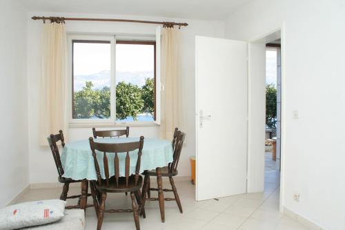 jadalnia ze stołem i krzesłami oraz oknem w obiekcie Apartments by the sea Zrnovska Banja, Korcula - 4363 w Korčuli