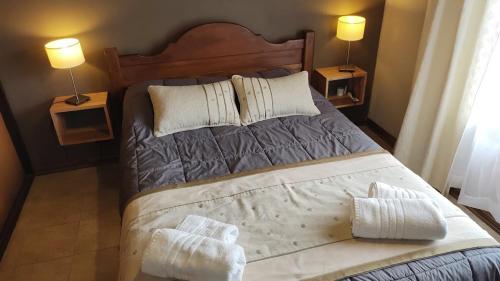 a bedroom with a large bed with two night stands at Casita Cavok in San Carlos de Bariloche