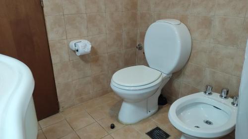 La salle de bains est pourvue de toilettes blanches et d'un lavabo. dans l'établissement Casita Cavok, à San Carlos de Bariloche