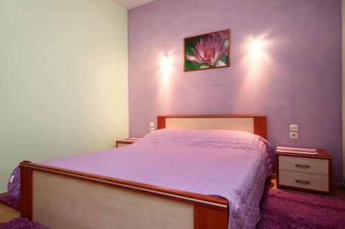 um quarto com uma cama com uma parede roxa em Apartments by the sea Racisce, Korcula - 4344 em Racisce