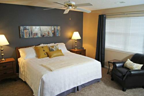 a bedroom with a bed with a ceiling fan and a chair at Branson Krehbiel Condo 2Bd 2Bath in Branson