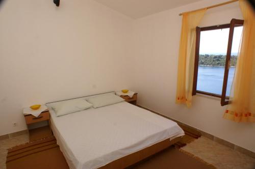 a small bedroom with a bed and a window at Apartments by the sea Karbuni, Korcula - 4465 in Prizba