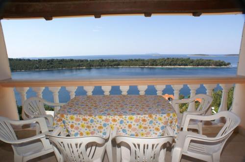 una mesa y sillas en un balcón con vistas al agua en Apartments by the sea Karbuni, Korcula - 4465, en Prizba