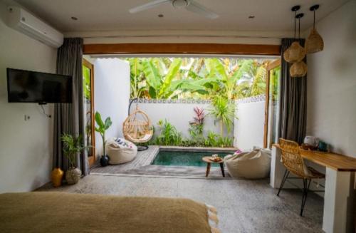 1 dormitorio con 1 cama y jardín con piscina en Tiga Studios - Adults Only, en Kuta Lombok