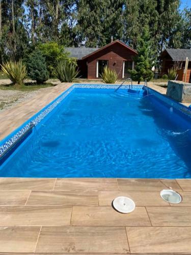 a large blue swimming pool with two frisbees in it at Hotel Boutique Family Suites in Panguipulli