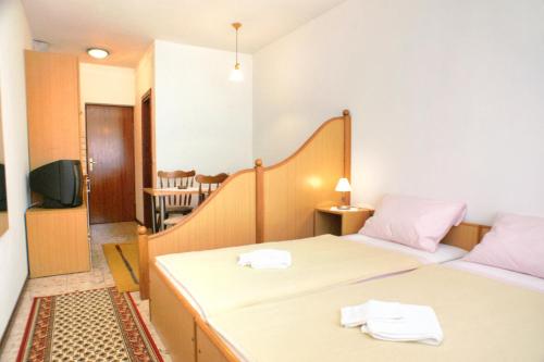 a small room with two beds and a television at Studio Orebic 4496d in Orebić