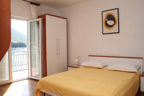 a bedroom with a bed and a large window at Studio Trstenik 4566b in Trstenik