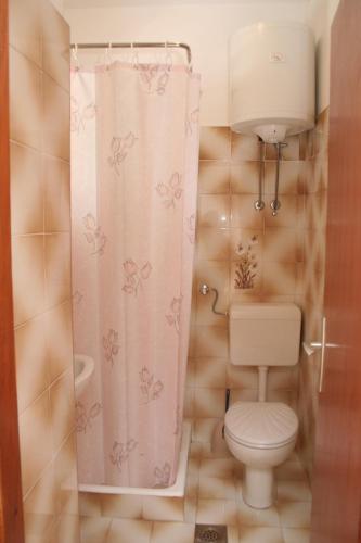 a bathroom with a toilet and a shower curtain at Studio Trstenik 4566b in Trstenik