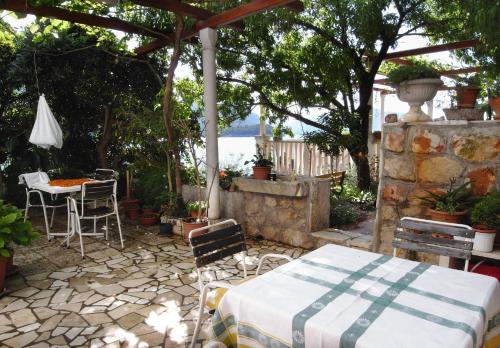 a patio with a table and chairs and an umbrella at Apartments and rooms by the sea Trstenik, Peljesac - 4566 in Trstenik