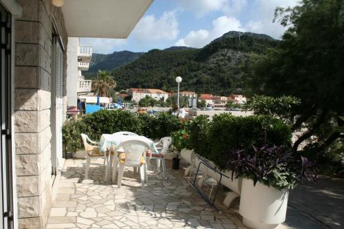a table and chairs on a patio with a view of a city at Apartments and rooms by the sea Trstenik, Peljesac - 4566 in Trstenik