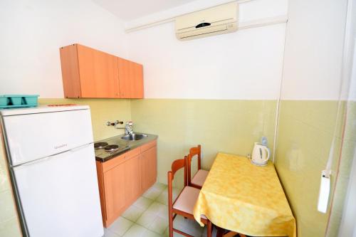 una piccola cucina con tavolo e frigorifero di Apartments and rooms by the sea Orebic, Peljesac - 4517 a Orebić (Sabbioncello)