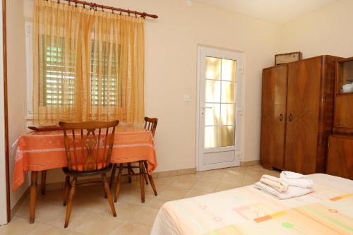 a room with a table and chairs and a window at Apartments with a parking space Lumbarda, Korcula - 4472 in Lumbarda