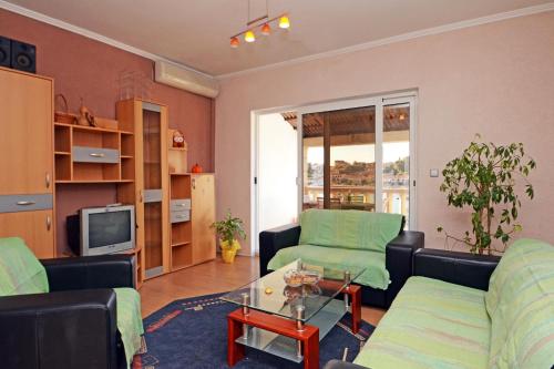 a living room with two couches and a tv at Apartments by the sea Brna, Korcula - 4425 in Smokvica