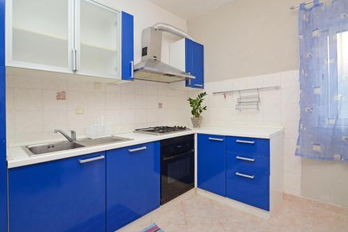 a blue kitchen with a sink and a stove at Apartments by the sea Brna, Korcula - 4425 in Smokvica