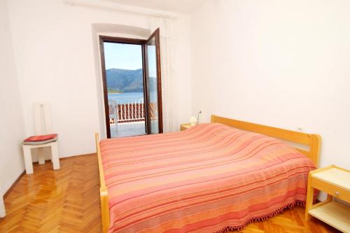 a bedroom with a bed and a large window at Apartments by the sea Kneza, Korcula - 4371 in Pupnat