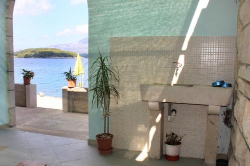a bathroom with a sink and a view of the water at Seaside holiday house Lumbarda, Korcula - 4422 in Lumbarda