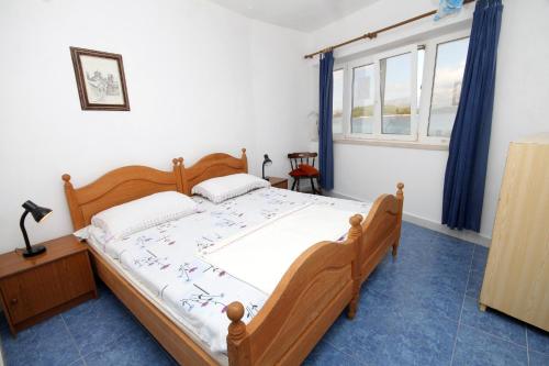 a bedroom with a wooden bed and a window at Seaside holiday house Lumbarda, Korcula - 4422 in Lumbarda