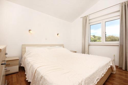 a white bedroom with a bed and a window at Apartments by the sea Cove Vrbovica bay - Vrbovica (Korcula) - 4452 in Korčula