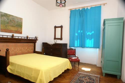 a bedroom with a bed and a dresser and blue curtains at Apartments by the sea Korcula - 4450 in Korčula