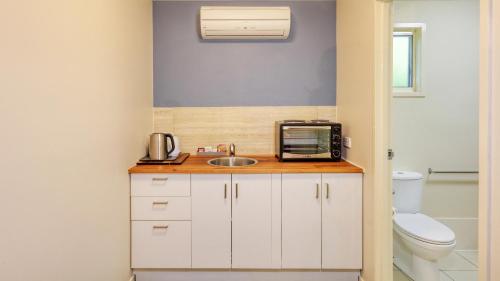 a bathroom with a sink and a toaster oven on a counter at Best Western Caboolture Gateway Motel in Caboolture