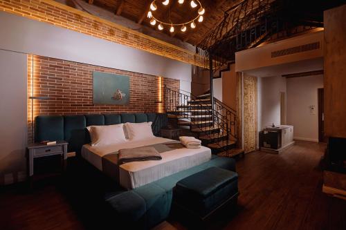 a bedroom with a large bed and a brick wall at Vecchia Boutique Hotel in Korçë