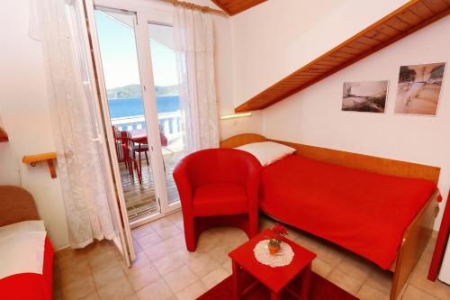 a bedroom with a red bed and a red chair at Apartment Racisce 4360a in Račišće