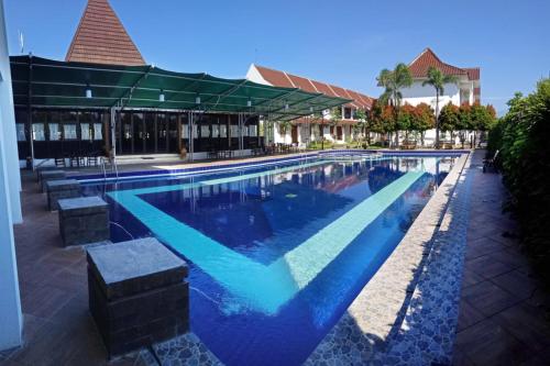 una gran piscina de agua azul en un edificio en Al Azhar Azhima Hotel Resort and Convention en Solo