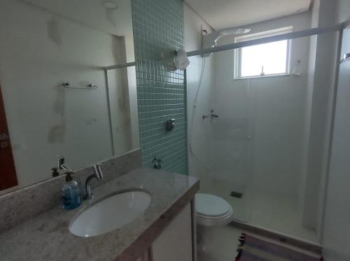 a bathroom with a sink and a shower and a toilet at Praia do Morro Frente para o Mar in Guarapari