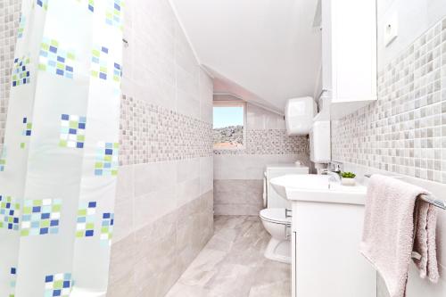 a white bathroom with a sink and a toilet at Apartments by the sea Vela Luka, Korcula - 4449 in Vela Luka