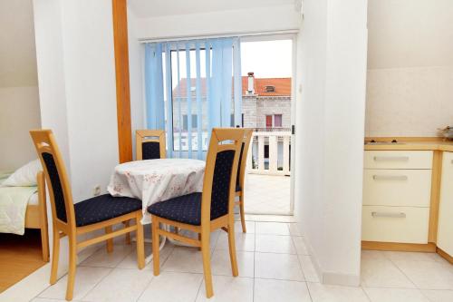 a dining room with a table and chairs and a balcony at Apartments with a parking space Korcula - 4433 in Korčula