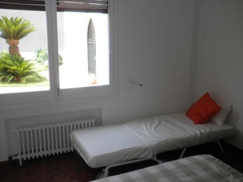 a bed and a couch in a room with a window at Apartament Can Batlle in Premiá de Mar
