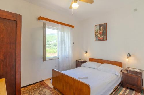 Schlafzimmer mit einem Bett mit weißer Bettwäsche und einem Fenster in der Unterkunft Apartments by the sea Prizba, Korcula - 4479 in Prizba