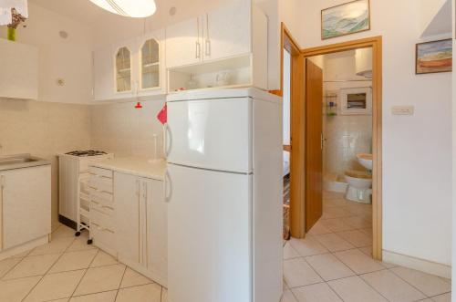 eine Küche mit weißen Schränken und einem weißen Kühlschrank in der Unterkunft Apartments by the sea Prizba, Korcula - 4479 in Prizba