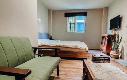 a living room with a bed and a couch at Woods Inn in Jiaoxi