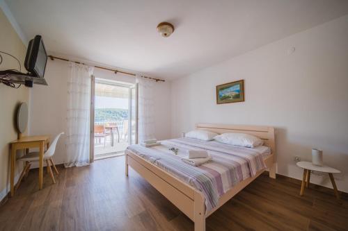 - une chambre avec un grand lit et un balcon dans l'établissement Apartments by the sea Lumbarda, Korcula - 4446, à Lumbarda