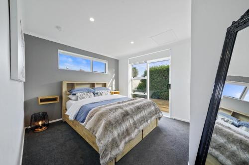 a bedroom with a large bed and a mirror at Treasure on Tuscan - Martinborough Holiday Home in Martinborough 