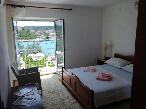 a bedroom with a bed and a balcony with a view at Apartments by the sea Lumbarda, Korcula - 4369 in Lumbarda