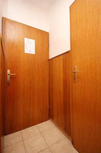 a hallway with two wooden doors in a room at Apartments and rooms by the sea Racisce, Korcula - 4341 in Račišće